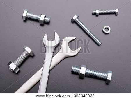 Wrenches And Bolts On A Dark Background. Industrial Still Life Of The Tool. Fastening Tool Top View.