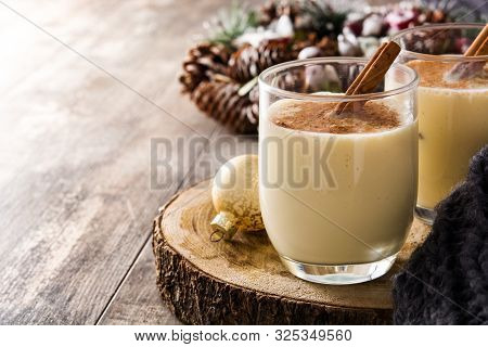 Homemade Eggnog With Cinnamon In Glass On Wooden Table. Typical Christmas Dessert. Copy Space