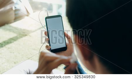 Young Man Relaxing Listening The Music From Mobile Phone.