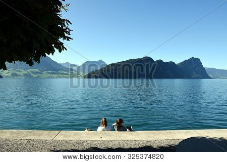 Vitznau, Switzerland 29.09.2019: Two Girls Sunbathing, Relaxing And Enjoying The Rays Of The Sun On 