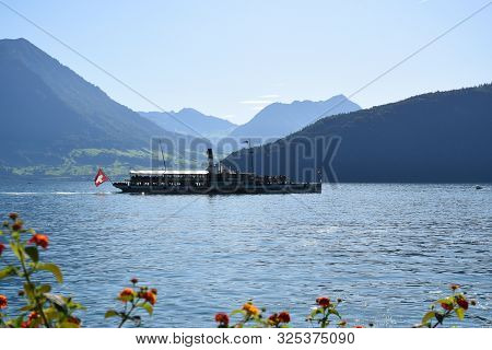 Vitznau, Switzerland 29.09.2019: A Steamboat With Swiss Flag On The Back Is Crossing Lake Lucerne