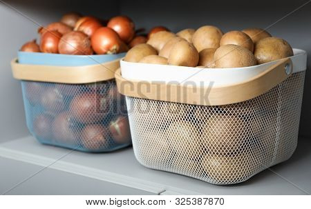Baskets With Potatoes And Onions On Shelf. Orderly Storage