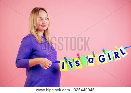 Beautiful Smiley Pregnant Big Belly Woman At 9 Months Of Pregnancy Hold A Cards With The Inscription