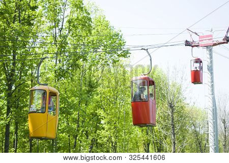 Kharkov, Ukraine - April 30, 2018: Three Colourful Cabins On Rope In The City Park. Panorama Of Cabl