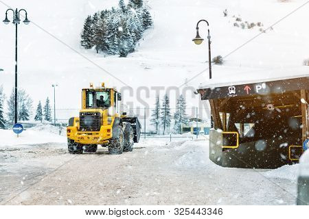 Big Loader Machine With Steel Metal Chains Removing Big Snow Pile From City Street At Alpine Mountai