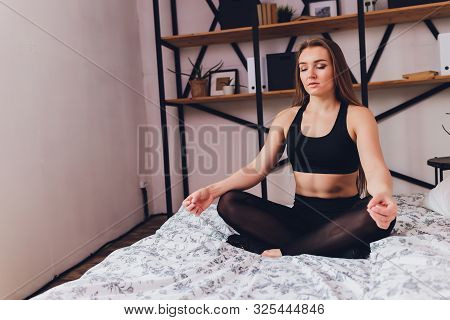 Attrctive Fitness Woman Doing Stretching Exercises At Home, As Part Of A Healthy Lifestyle Without G