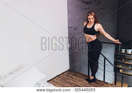 Attrctive Fitness Woman Doing Stretching Exercises At Home, As Part Of A Healthy Lifestyle Without G