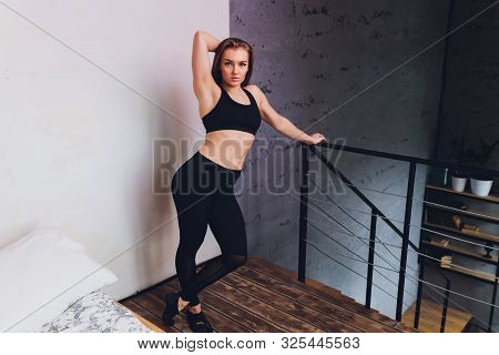 Attrctive Fitness Woman Doing Stretching Exercises At Home, As Part Of A Healthy Lifestyle Without G