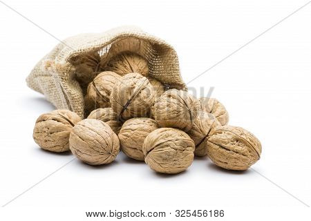 Pile Of Walnuts In Juta Bag On White Background