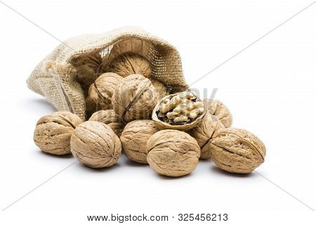 Pile Of Walnuts In Juta Bag On White Background
