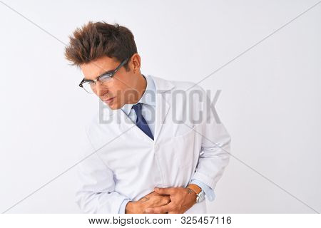 Young handsome sciencist man wearing glasses and coat over isolated white background with hand on stomach because indigestion, painful illness feeling unwell. Ache concept.