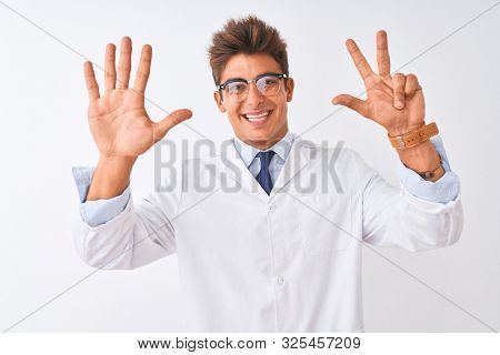 Young handsome sciencist man wearing glasses and coat over isolated white background showing and pointing up with fingers number eight while smiling confident and happy.
