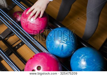 Close-up Hand Holding Bowling Ball Against Bowling Alley - Image. Cheerful Woman Isready To Play - I