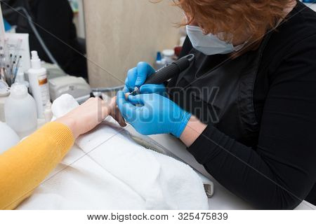 Close-up Of Professional Finger Nail Treatment, Grinding And Polishing With Electric Nail File Drill