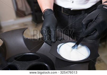Male Stylist In Gloves Preparing Color Cream For Dying Hairin  A Container, A Mask For Treatment Pro