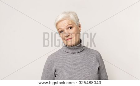 Portrait Of Sceprical Senior Woman Over Light Stidio Background, Panorama With Copy Space