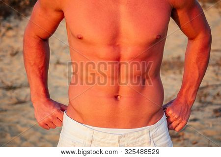 Sexy Naked Tanned Torso Abs Muscles Press Of A Man On The Beach