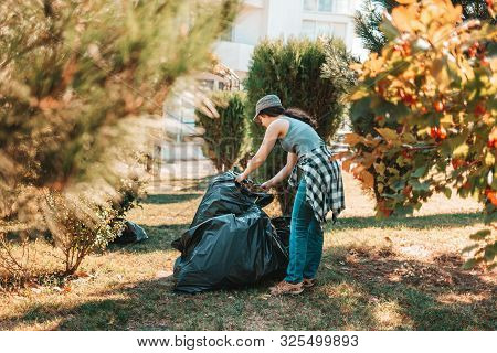 The Concept Of Environmental Pollution And Earth Day. A Female Volunteer Does Cleaning In The Park I