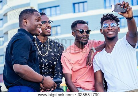 A Group Of Four Fashionable Cool African American Guys Students Communicating On The Street Looking 
