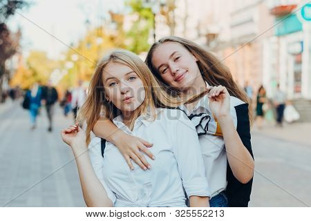 Happy Brightful Positive Moments Of Two Stylish Girls Hugging On Street In City. Closeup Portrait Fu