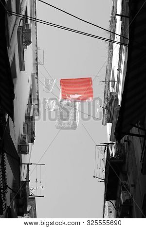 Washing Lines Betwwen Two Buildings And One Red Bedsheet With Black And White Effect