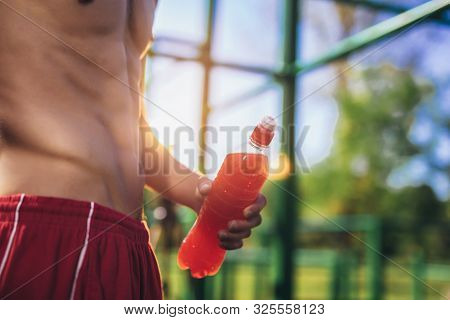 Sportsman With Naked Torso Maintaining Healthy Lifestyle Standing Leaning On Trainer Outdoors Holdin