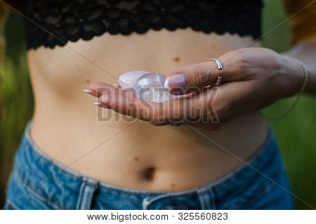 Female Hands Holding Two Yoni Eggs For Vumfit, Imbuilding Or Meditation Are Made From Pink Quartz An