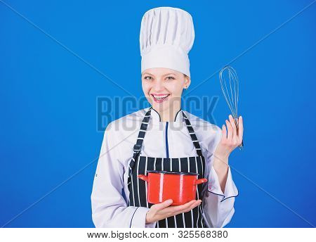 Handling Kitchen Tasks With Ease. Professional Cook Smiling With Pot And Whipping Tool In Kitchen. C