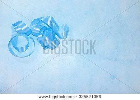 Background With Festive Blue Neon Ribbon On A Blue Table, Top View, Flat Lay. Place For Your Text An