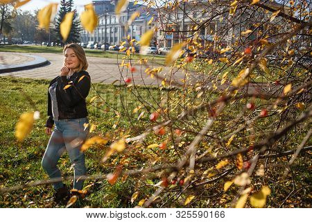 Happy Young Curvy Woman Looking Up Outdoors In Fall. Girl Enjoying Warm Sunny Weather. She Wearing I