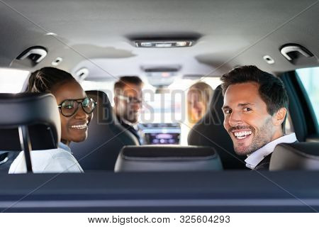 Group Of Cheerful Multi Racial Friends Sitting In Car Enjoying Road Trip Travel