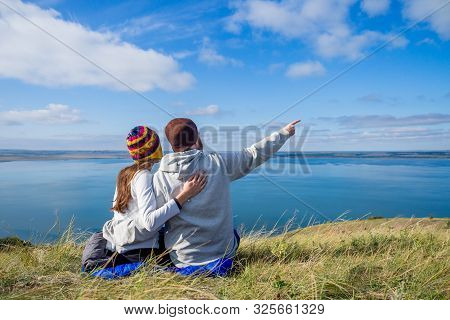 Beautiful Caucasian Woman And Handsome Scots Man Sitting Down In A Sleeping Bag And Hugging , Pointi