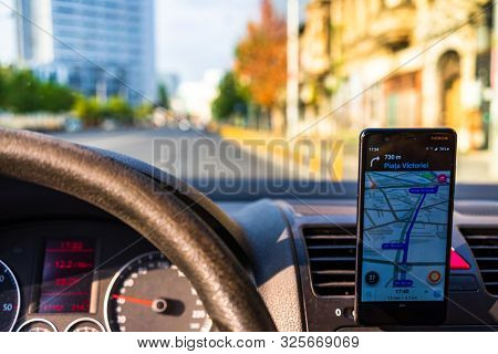 In Car Dashboard View With Smartphone Showing Waze Maps To Show The Way Thru The City In Bucharest,