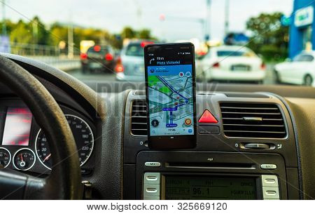 In Car Dashboard View With Smartphone Showing Waze Maps To Show The Way Thru The City In Bucharest,