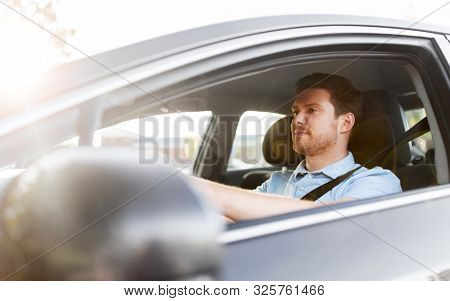 transport, vehicle and people concept - man or driver driving car in summer