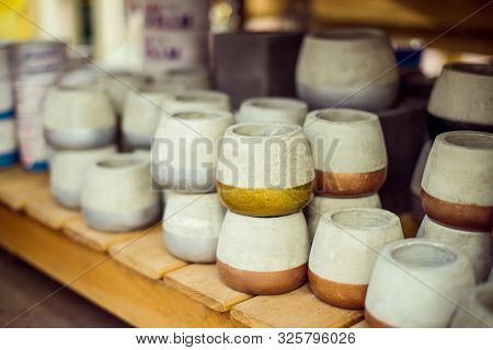 Assortment Of Gray Color Cement Flower Pots With Colored Part Selling In Gardening Store. Pile Of Po
