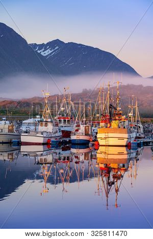 Laukvik, Lofoten Islands, Norway, Fishing boats in harbor at midnight sun, Mountain With Snow In Background