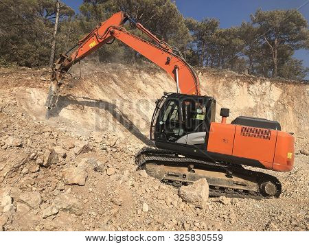 Hydrohammer Is Crushing Rocks During Road Construction Works On The Rocky Soils. Heavy Machinery At 