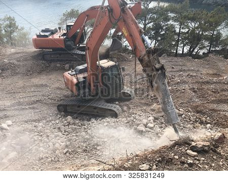 Hydrohammer Is Crushing Rocks During Road Construction Works On The Rocky Soils. Heavy Machinery At 