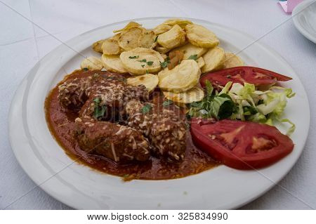 Omato Dumplings And Potato Fries On A White Plate