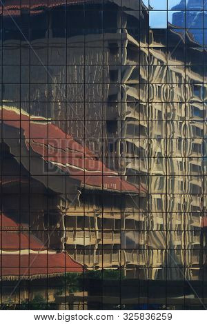 Modern Building Curtain Wall Reflecting Retro Traditional Style Building In The Facade. Clean Glasse