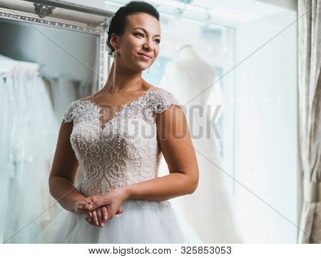 Beautifu bride choosing wedding dress in a wedding salon