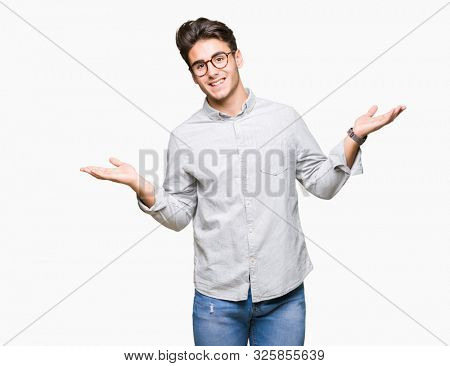 Young handsome man wearing glasses over isolated background Smiling showing both hands open palms, presenting and advertising comparison and balance