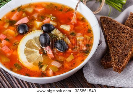 Traditional Russian Meat Soup Solyanka In Bowl On Rustic Wooden Table
