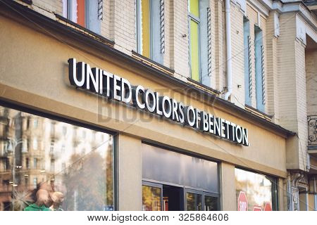 United Colors Of Benetton Brend Sign On City Street. Signboard Logo Of Benetton Group S.r.l. Global