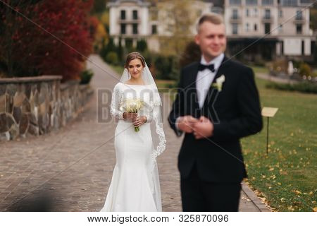 Stylish Couple Walking In The Park At Their Wedding Day. Happy Newlyweds Outside In Autumn Weather. 