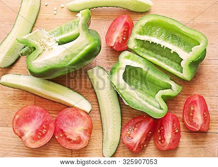 Fresh Green Papper, Cucumber And Tomotos Cut Into Pieces On The Wooden Cutting Board. Vegan Good