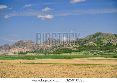 Flat Fields And Arid Hills, Macin Mountains In Romania.