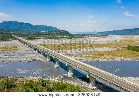bridge over river with golden miscanthus under sky