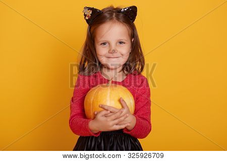 Portrait Of Little Girl Wearing Redsweater, Having Mustache And Ears Of Cat, Charming Kid Stands Smi